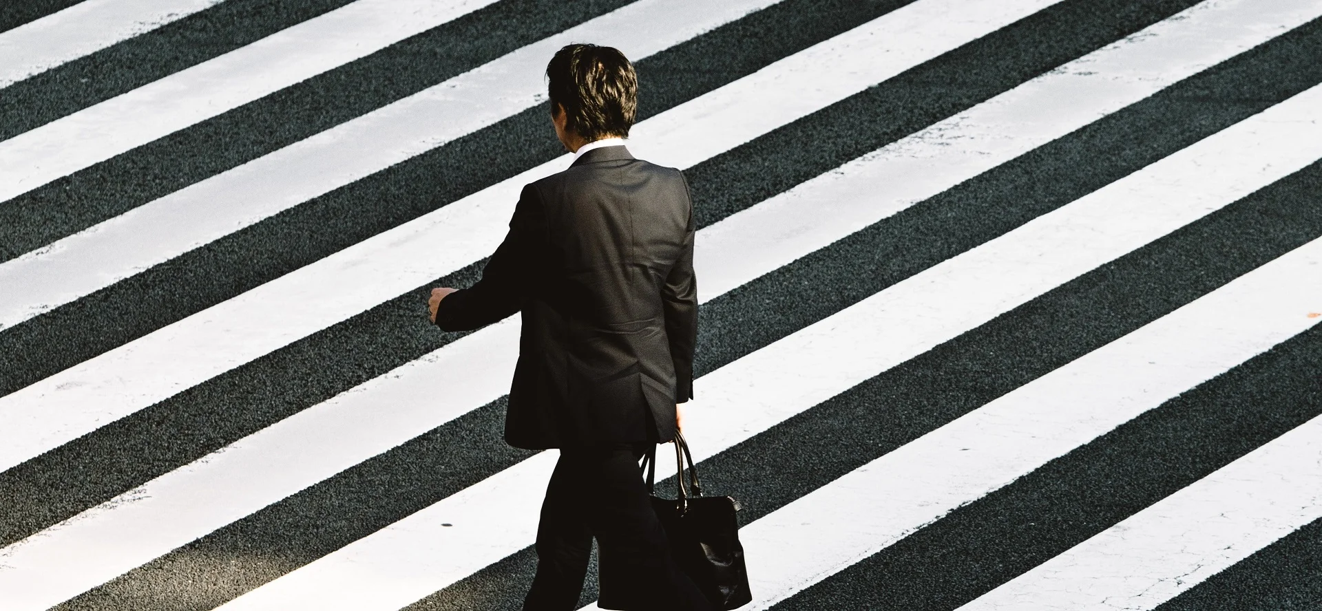 homme de dos traversant la rue