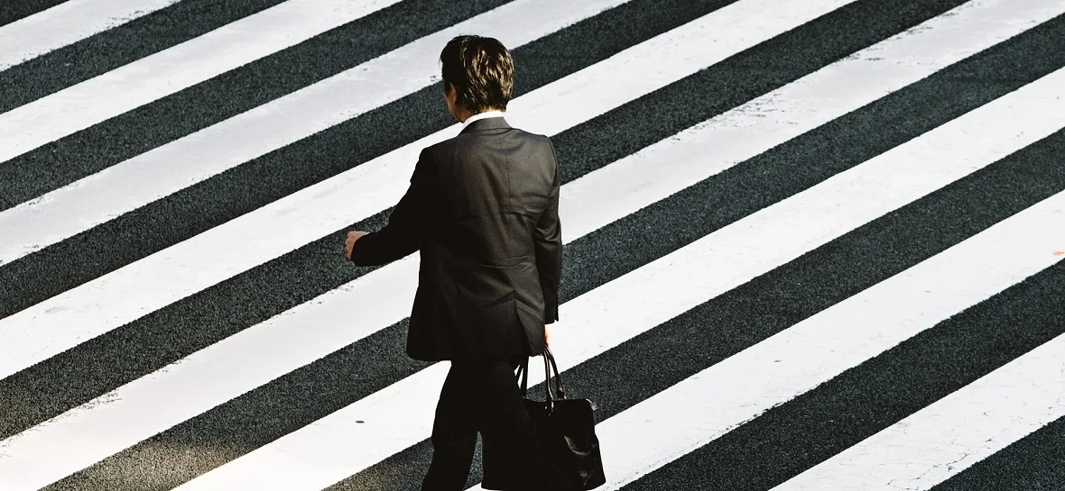 homme de dos traversant la rue